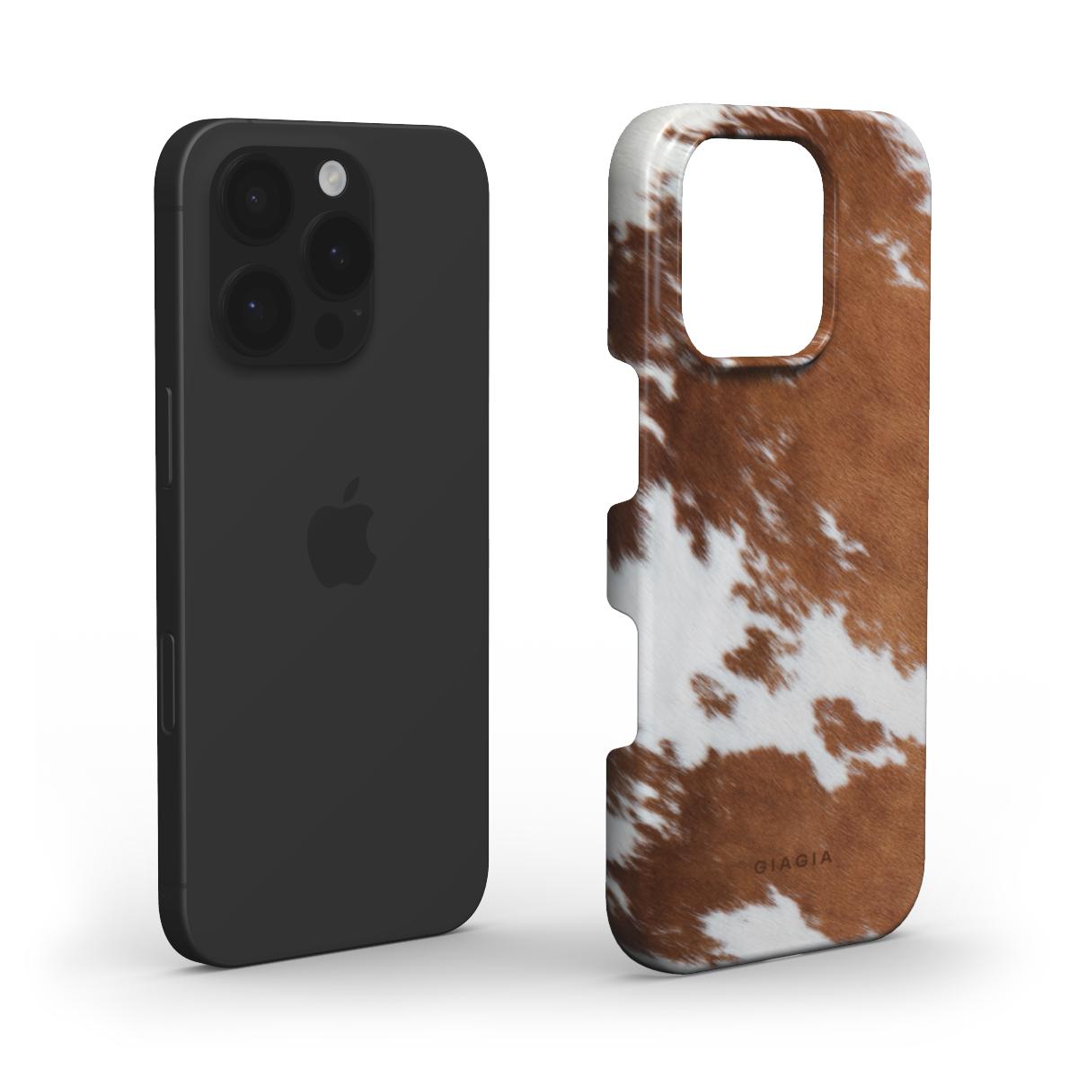 Black phone case and cow print phone case on a white background