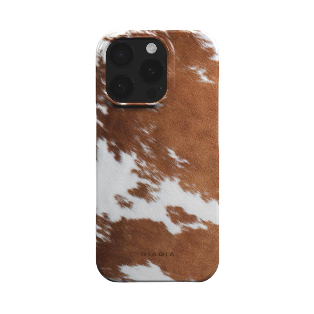 Phone case with brown and white cow print pattern on a white background